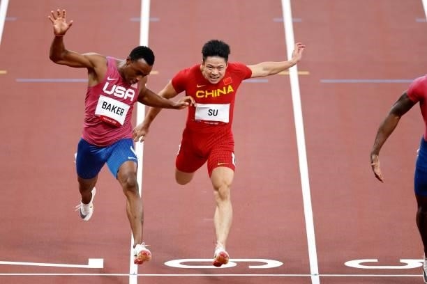 Ronnie Baker of United States and Su Bingtian of China cross the finish line in the Men's 100m Final on day nine of the Tokyo 2020 Olympic Games at...