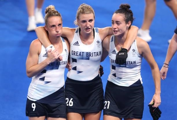 Susannah Townsend, Lily Owsley and Fiona Anne Crackles of Team Great Britain leave the pitch following victory in the Women's Quarterfinal match...