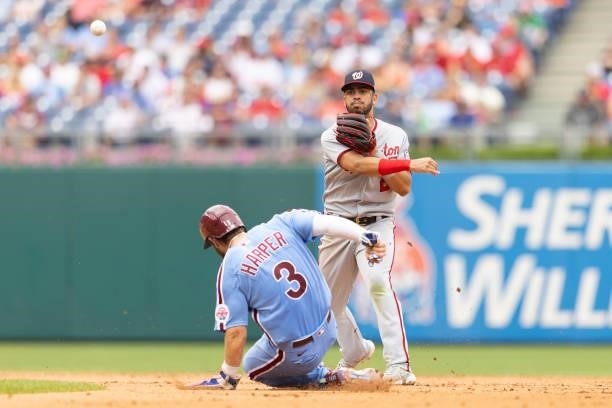 Luis Garcia of the Washington Nationals attempts to turn a double play against Bryce Harper of the Philadelphia Phillies during Game One of the...