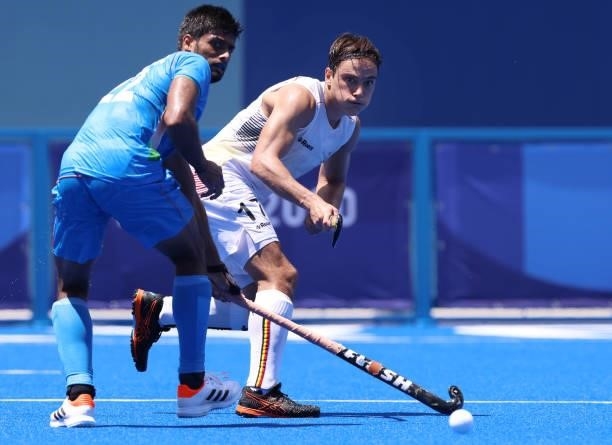 Thomas Briels of Team Belgium passes the ball against Varun Kumar of Team India during the Men's Semifinal match between India and Belgium on day...