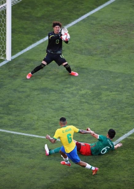 Guilherme Arana of Team Brazil shoots whilst under pressure from Vladimir Lorona of Team Mexico during the Men's Football Semi-final match between...
