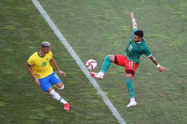 Alexis Vega of Team Mexico controls the ball whilst under pressure from Richarlison of Team Brazil during the Men's Football Semi-final match between...