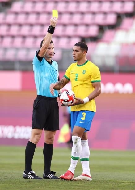 Match Referee, Georgi Nikolov Kabakov shows Carlos Diego of Team Brazil a yellow card during the Men's Football Semi-final match between Mexico and...