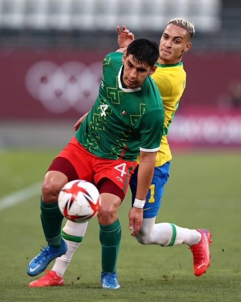 Jesus Angulo of Team Mexico shields the ball away from Antony of Team Brazil during the Men's Football Semi-final match between Mexico and Brazil on...