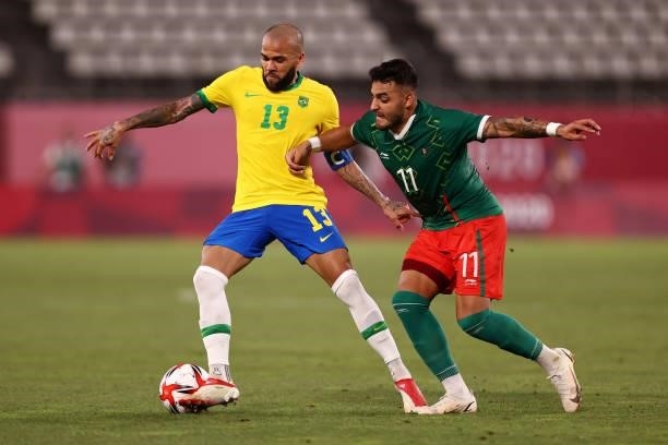 Dani Alves of Team Brazil battles for possession with Alexis Vega of Team Mexico during the Men's Football Semi-final match between Mexico and Brazil...