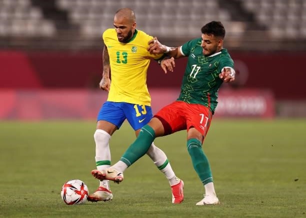 Dani Alves of Team Brazil battles for possession with Alexis Vega of Team Mexico during the Men's Football Semi-final match between Mexico and Brazil...