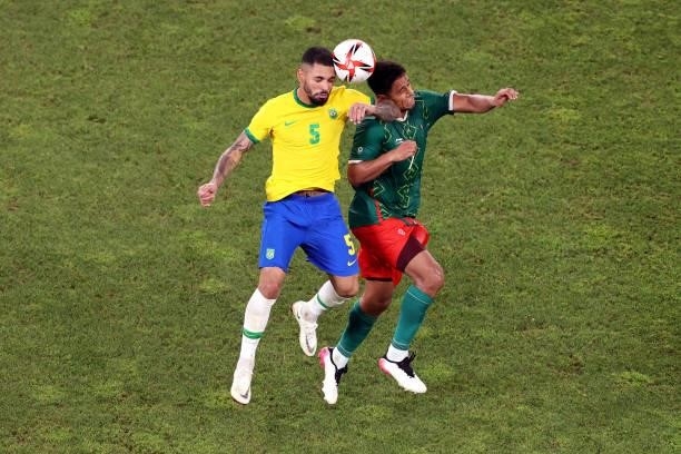 Luiz Douglas of Team Brazil battles for possession with Luis Romo of Team Mexico during the Men's Football Semi-final match between Mexico and Brazil...