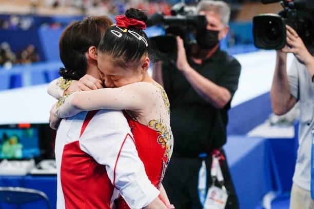 Guan Chenchen of Team China celebrates with her coach after winning the Women's Balance Beam Final on day eleven of the Tokyo 2020 Olympic Games at...