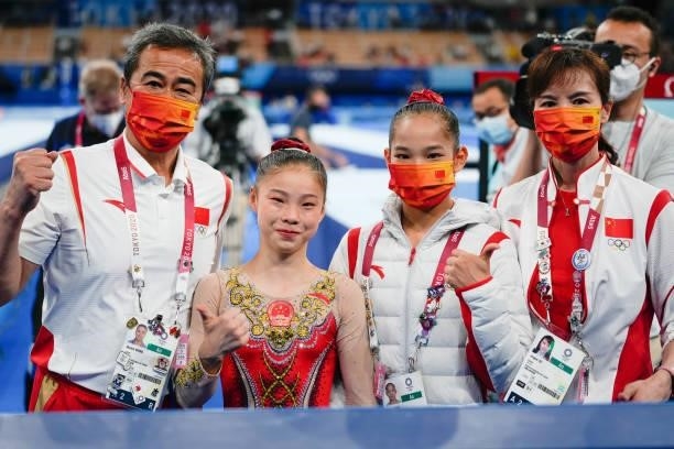 Silver medalist Tang Xijing of Team China, gold medalist Guan Chenchen of Team China celebrate with their coaches after the Women's Balance Beam...