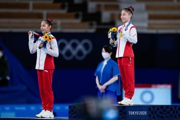 Silver medalist Tang Xijing of Team China and gold medalist Guan Chenchen of Team China celebrate on the podium after the Women's Balance Beam Final...