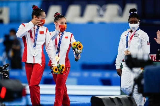 Silver medalist Tang Xijing of Team China, gold medalist Guan Chenchen of Team China and bronze medalist Simone Biles of Team United States celebrate...