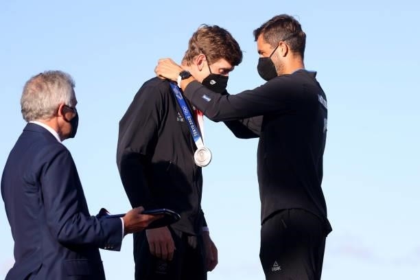 Peter Burling and Blair Tuke of Team New Zealand present each other with their silver medals for the Men's Skiff 49er class on day eleven of the...
