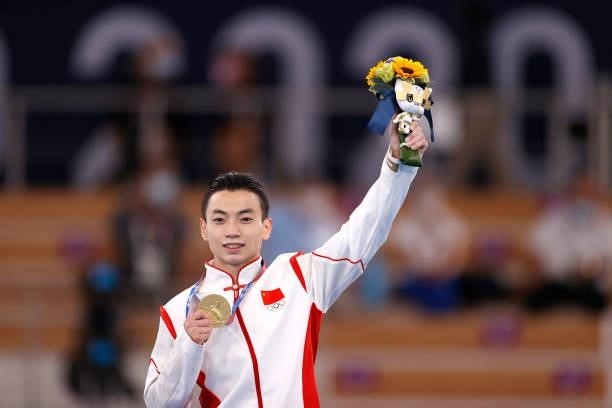 Gold medalist Zou Jingyuan of Team China celebrate on the podium after the Men's Parallel Bars Final on day eleven of the Tokyo 2020 Olympic Games at...