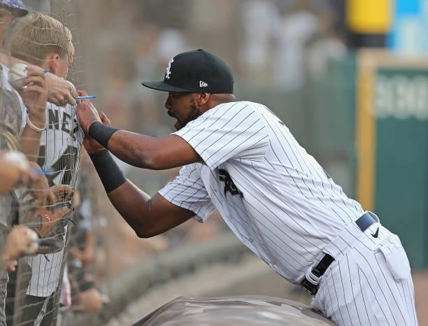 Eloy Jimenez of the Chicago White Sox signs the jersey of a young fan before a game against the Kansas City Royals at Guaranteed Rate Field on August...