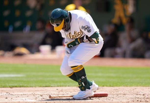 Josh Harrison of the Oakland Athletics reacts in pain after he was hit with a pitch from Joe Musgrove of the San Diego Padres in the bottom of the...