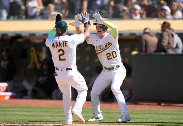 Mark Canha and Starling Marte of the Oakland Athletics celebrate after they scored on a walk-off RBI double hit off the bat of Matt Olson in the 10th...