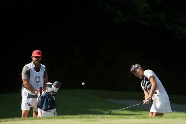 Lexi Thompson of Team United States chips to the 17th green as caddie Drew Hinesley looks on during the second round of the Women's Individual Stroke...