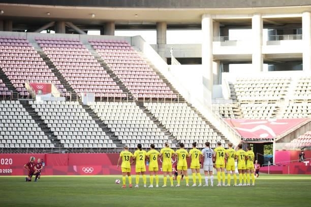 Players of Team Australia stand and link arms as players of Team United States take a knee in support of the Black Lives Matter movement prior to the...