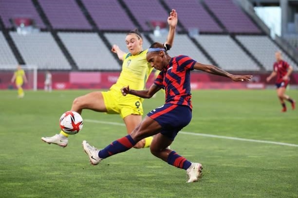 Crystal Dunn of Team United States clears the ball whilst under pressure from Caitlin Foord of Team Australia during the Women's Bronze Medal match...