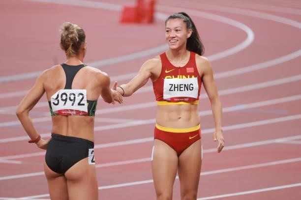 Zheng Ninali of Team China shakes hands with Ekaterina Voronina of Team Uzbekistan afater the Women's Heptathlon 800m heats on day thirteen of the...