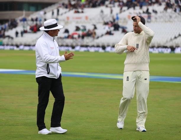 Joe Root, captain of England talks to umpire Richard Kettleborough as rain stops play during day two of the First LV= Insurance test match between...