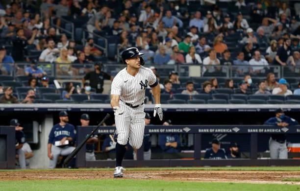 Giancarlo Stanton of the New York Yankees follows through on his seventh inning base hit against the Seattle Mariners at Yankee Stadium on August 05,...