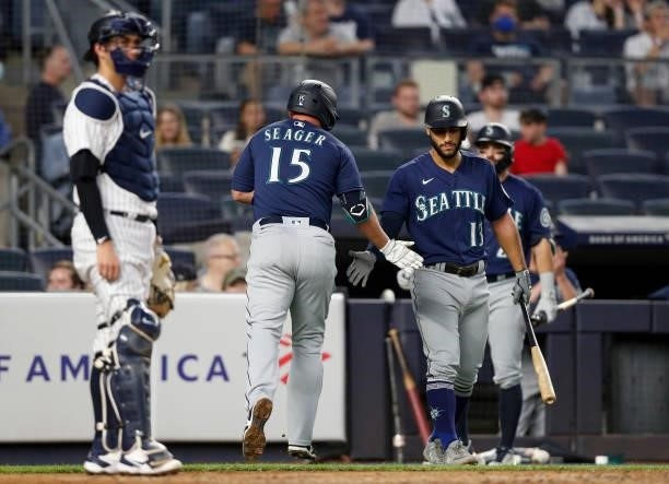 Kyle Seager of the Seattle Mariners celebrates his fourth inning home run against the New York Yankees with teammate Abraham Toro at Yankee Stadium...