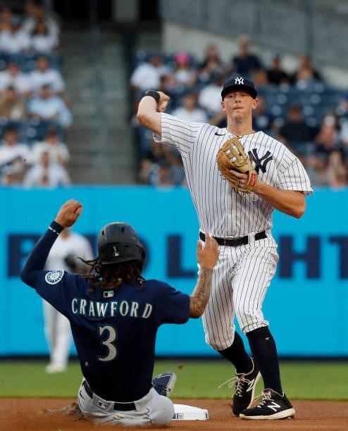 LeMahieu of the New York Yankees completes a first inning double play after forcing out J.P. Crawford of the Seattle Mariners at Yankee Stadium on...