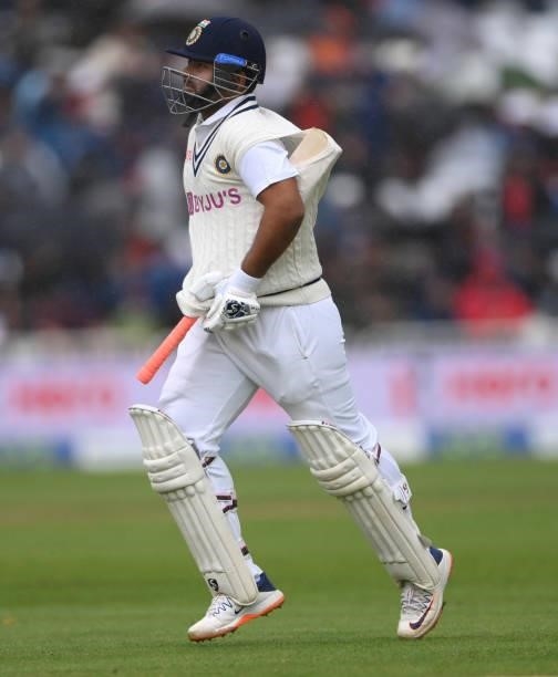 India batsmen Rishabh Pant shelters his bat under his sweater as the teams come off for rain during day three of the First Test Match between England...