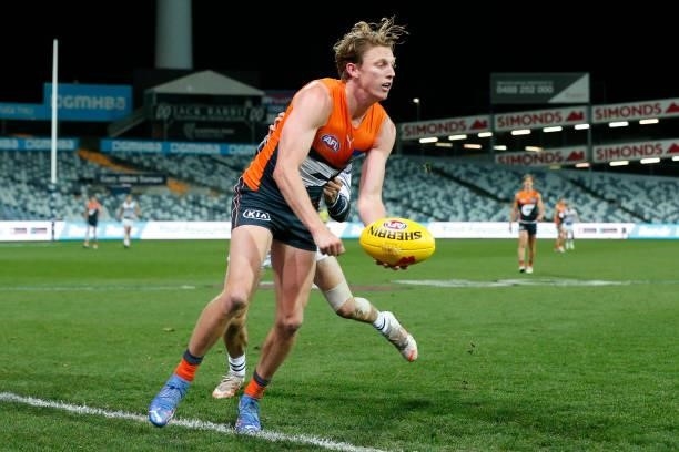 Lachie Whitfield of the Giants handballs during the round 21 AFL match between Geelong Cats and Greater Western Sydney Giants at GMHBA Stadium on...
