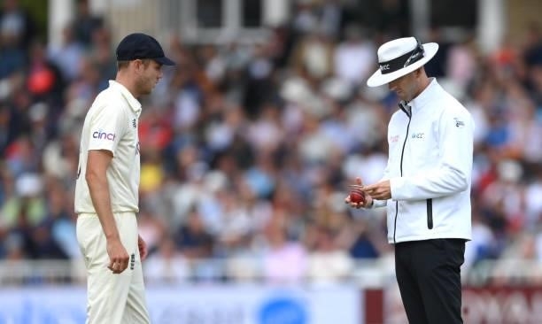 England bowler Stuart Broad looks on as umpire Michael Gough checks the shape of the ball during day three of the First Test Match between England...