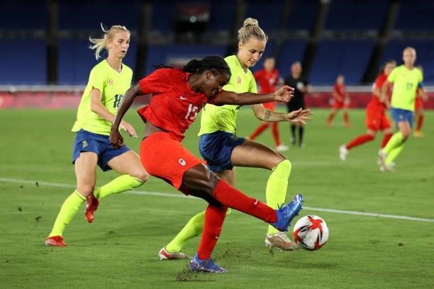 Nichelle Prince of Team Canada crosses the ball whilst under pressure from Nathalie Bjorn of Team Sweden during the Women's Gold Medal Match between...