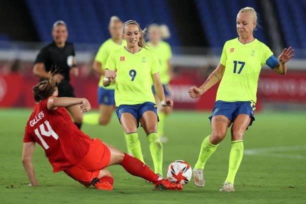 Kosovare Asllani and Caroline Seger of Team Sweden are tackled by Vanessa Gilles of Team Canada during the Women's Gold Medal Match between Canada...