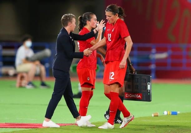 Christine Sinclair of Team Canada shakes hands with Bev Priestman, Head Coach of Team Canada as she is substituted off during the Women's Gold Medal...
