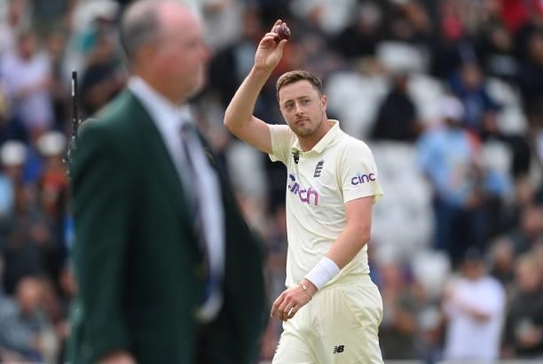 Ollie Robinson of England holds up the ball as he leaves the field having claimed five wickets during the third day of the 1st LV= Test match between...