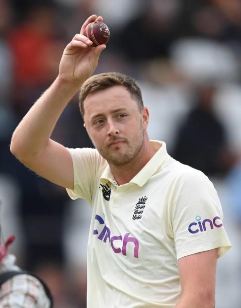 Ollie Robinson of England holds up the ball as he leaves the field having claimed five wickets during the third day of the 1st LV= Test match between...