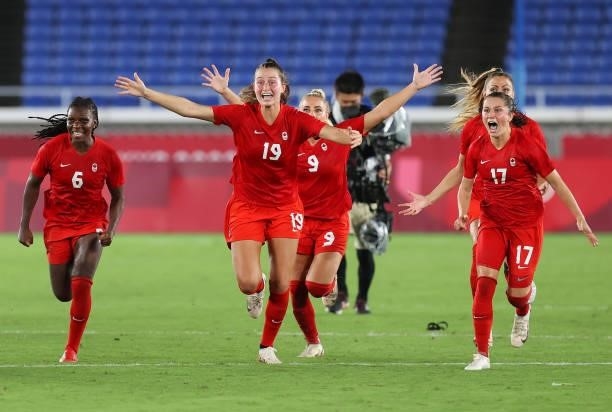 Deanne Rose, Jordyn Huitema and Jessie Fleming of Team Canada celebrate their team's winning penalty in the shootout in the Women's Gold Medal Match...