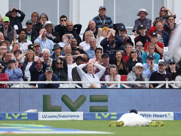 The spectators react as James Anderson misses a catch during day three of the First LV= Insurance test match between England and India at Trent...
