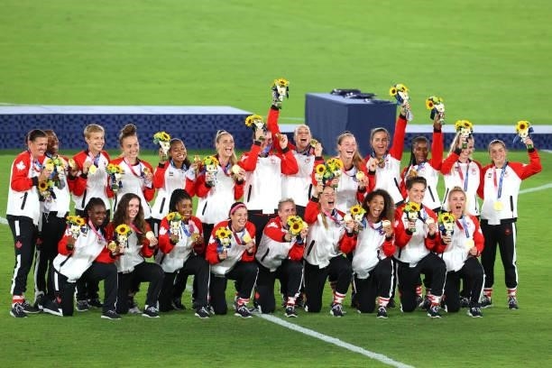 Team Canada poses with their medals after defeating Team Sweden during the women's football gold medal match between Canada and Sweden on day...