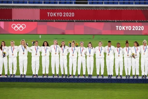 Bronze medalists Team USA celebrate on the podium with their bronze medals during the Women's Football Competition Medal Ceremony on day fourteen of...