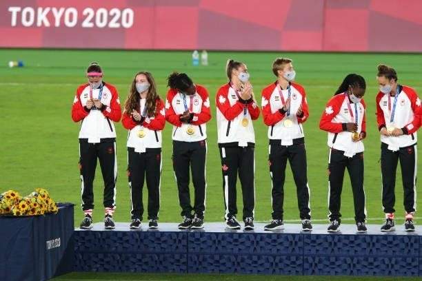Gold medalist Quinn of Team Canada and teammates celebrate on the podium with their gold medals during the Women's Football Competition Medal...