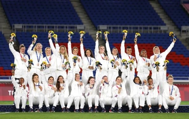 Bronze medalists of Team United States celebrate with their bronze medals during the Women's Football Competition Medal Ceremony on day fourteen of...