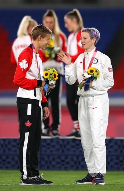 Gold medalist Quinn of Team Canada interacts with Bronze medalist Megan Rapinoe of Team United States during the Women's Football Competition Medal...