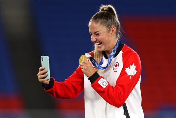 Gold medalist Janine Beckie of Team Canada poses with her gold medal during the Women's Football Competition Medal Ceremony on day fourteen of the...