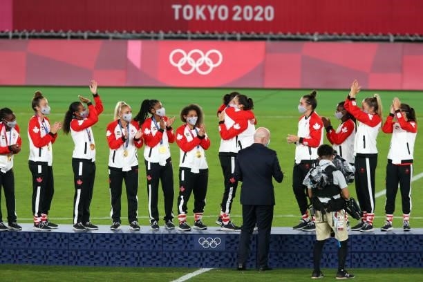 Gianni Infantino, President of FIFA presents the gold medals to Team Canada during the Women's Football Competition Medal Ceremony on day fourteen of...