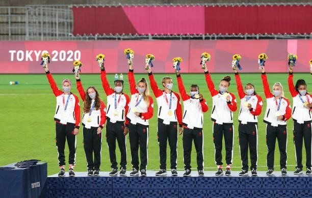 Gold medalist Quinn of Team Canada and teammates celebrate on the podium with their gold medals during the Women's Football Competition Medal...