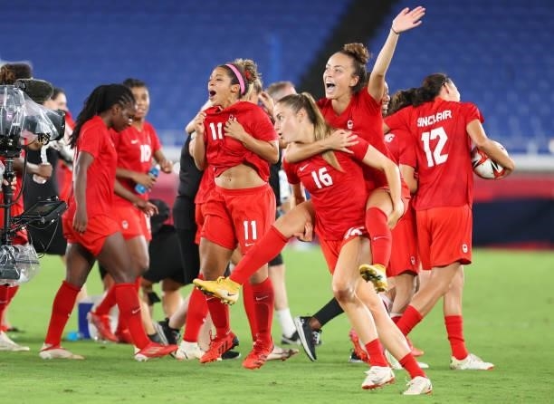 Janine Beckie of Team Canada carries teammate Julia Grosso as they celebrate their team's victory in the penalty shoot out during the Women's...