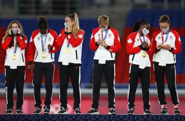 Gold medalist Shelina Zadorsky and Quinn of Team Canada react with their gold medals during the Women's Football Competition Medal Ceremony on day...