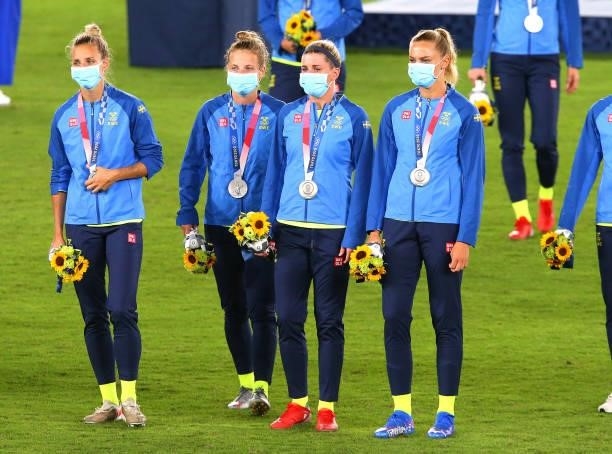 Silver medalists and players of Team Sweden look on after receiving their silver medals during the Women's Football Competition Medal Ceremony on day...