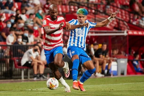 Dimitri Foulquier of Granada CF competes for the ball with Kevin of Malaga CF during the Ciudad de Granada trophy match between Granada CF and Malaga...